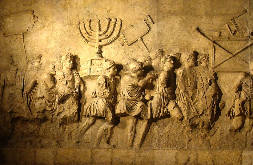  The menorah from the Second Temple is depicted being carried by Romans on the Arch of Titus. (photo credit: AMOS BEN GERSHOM/GPO)